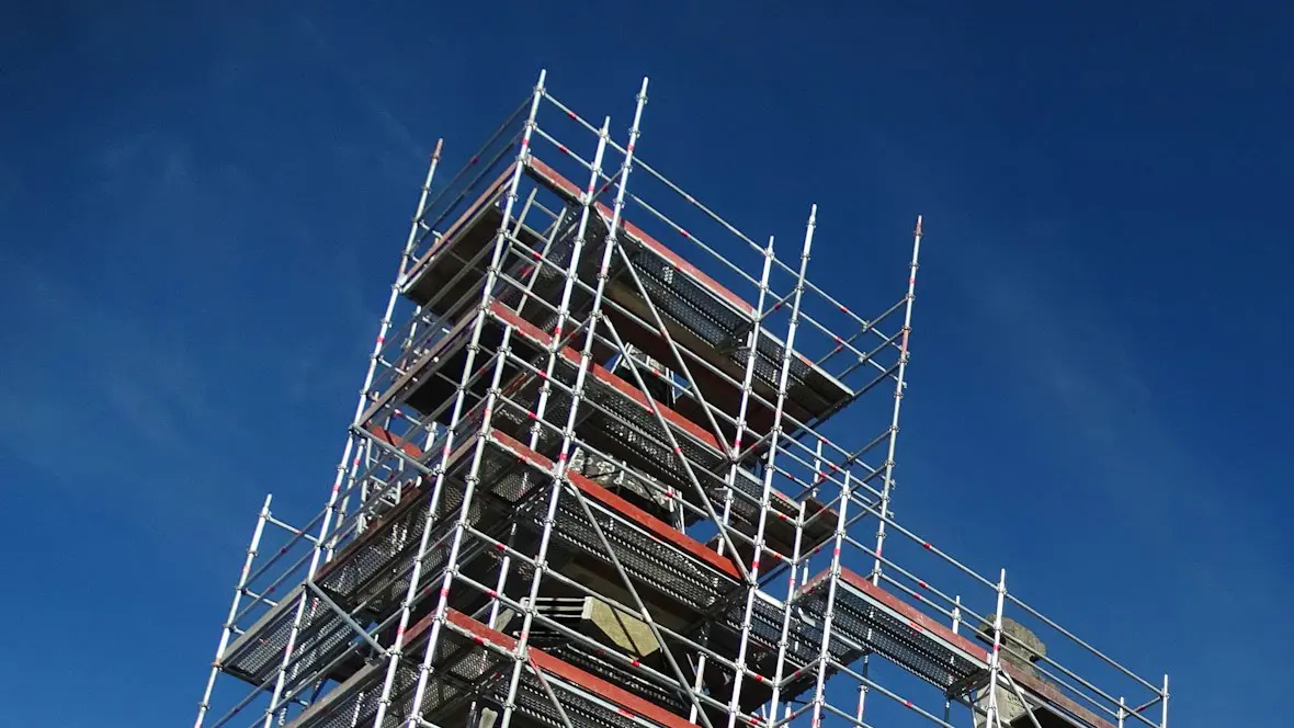 Modulgerüst an einem Altbau-Turm mit Belägen und Seitenschutz auf allen Lagen